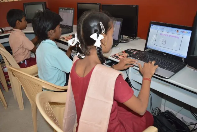 Girls at computers in a classroom